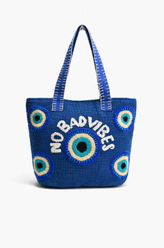 Closeup of Evil Eye embroidery on blue jute tote bag