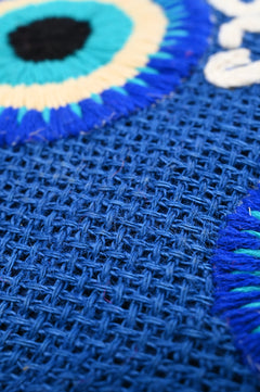 Close-up of Evil Eye embroidery on blue jute tote bag by Boho Girl