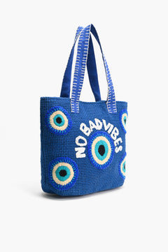 Closeup of Evil Eye embroidery on blue jute tote bag