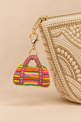 Beaded duffle bag charm with neon sequins clipped on a pearl embellished handbag
