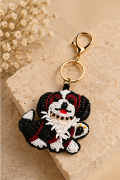 Bella black and white beaded dog keychain with red nose on a gold stand