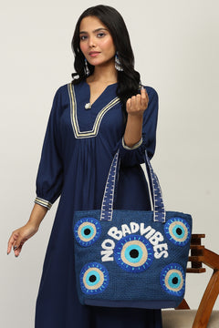 Closeup of Evil Eye embroidery on blue jute tote bag
