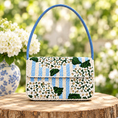 Blue and cream striped beaded shoulder bag with white floral embroidery, green leaves and blue strap