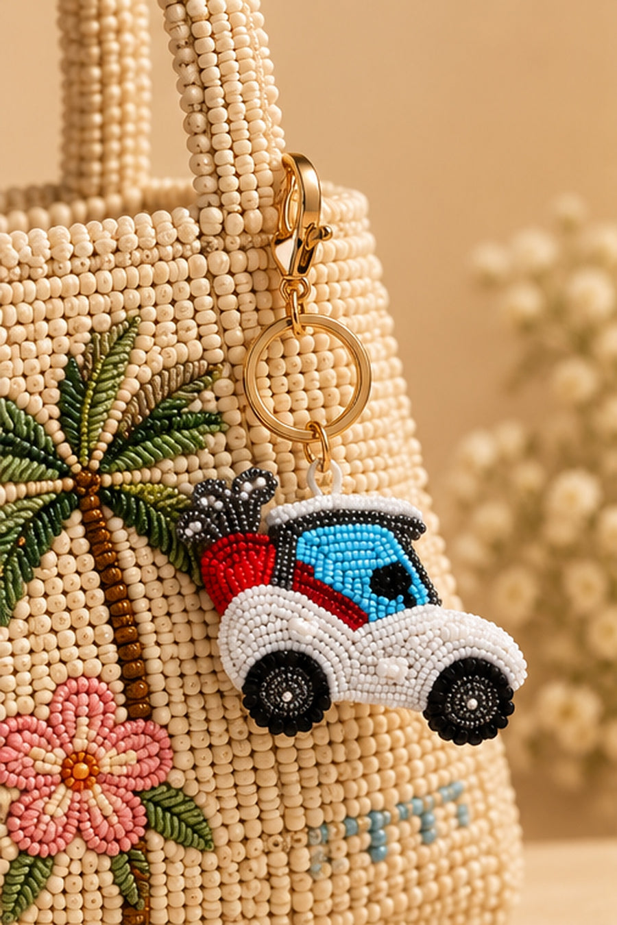 White and blue beaded golf cart keychain with red golf bag on a stone tray