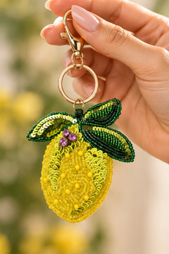 Close-up of hand stitched yellow beads and lime green sequins on a lemon keychain